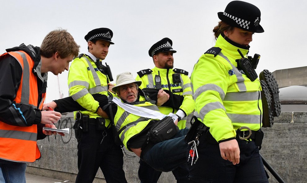 16/04/2019 - Policías británicos llevan a un activista mientras retiran a los manifestantes de su bloqueo del puente de Waterloo | AFP/ Ben Stansall