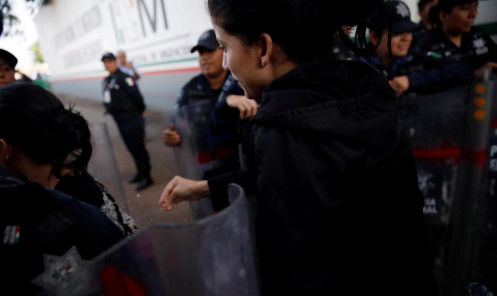 Una migrante cubana pasa entre los oficiales de la Policía Federal Mexicana mientras huye de las instalaciones de migración Siglo XXI en Tapachula. / Reuters