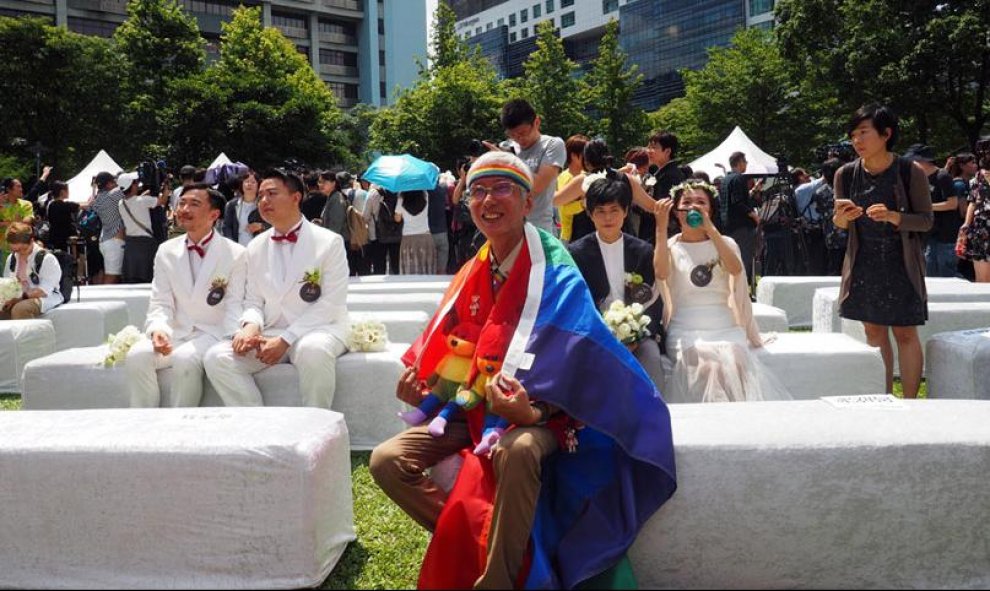 23/05/2019.- El activista por los derechos de los homosexuales Chi Chia-wei (c) lleva una bandera del arco iris durante el primer día del registro civil para matrimonios del mismo sexo este jueves, en Taipei (Taiwán). Taiwán se convirtió en el primer paí
