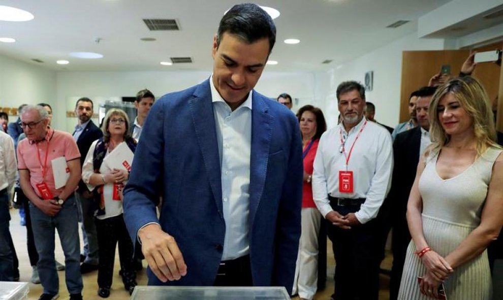 El presidente del gobierno Pedro Sánchez, acompañado de su mujer Begoña Gómez (d), vota esta mañana en un colegio de la localidad madrileña de Pozuelo de Alarcón.  EFE/JJ Guillén