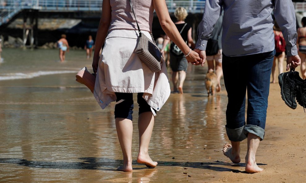 Numerosos donostiarras y visitantes disfrutan de una soleada jornada en la playa de La Concha de San Sebastián, donde este viernes los cielos se presentan poco nubosos o despejados salvo algún intervalo de nubes altas | EFE