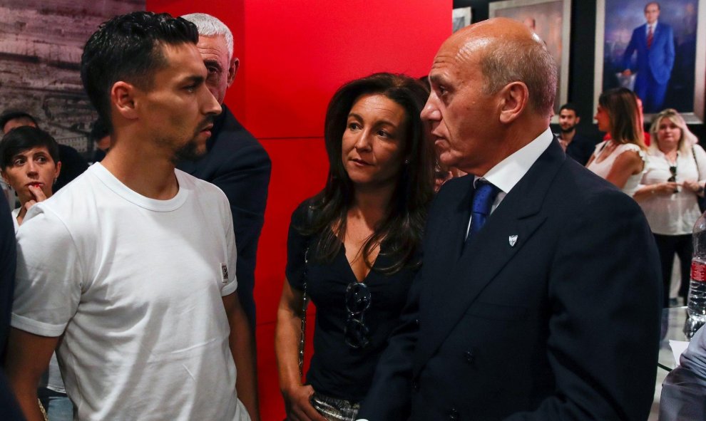 El capitán del Sevilla Jesús Navas (i), conversa con el expresidente del club, José María del Nido (d), tras despedir al futbolista José Antonio Reyes. | EFE