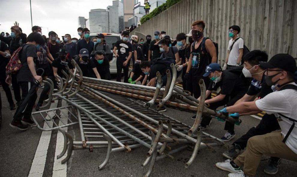 Manifestantes usan barreras para construir una barricada en una calle principal durante un mitin contra las enmiendas a un proyecto de ley de extradición cerca del Consejo Legislativo en Hong Kong, China, el 12 de junio de 2019. EFE / Jerome Favre