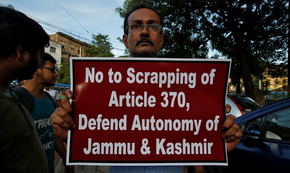 Un hombre muestra una pancarta durante una protesta contra la eliminación del estatus constitucional especial para Cachemira, en India | Reuters