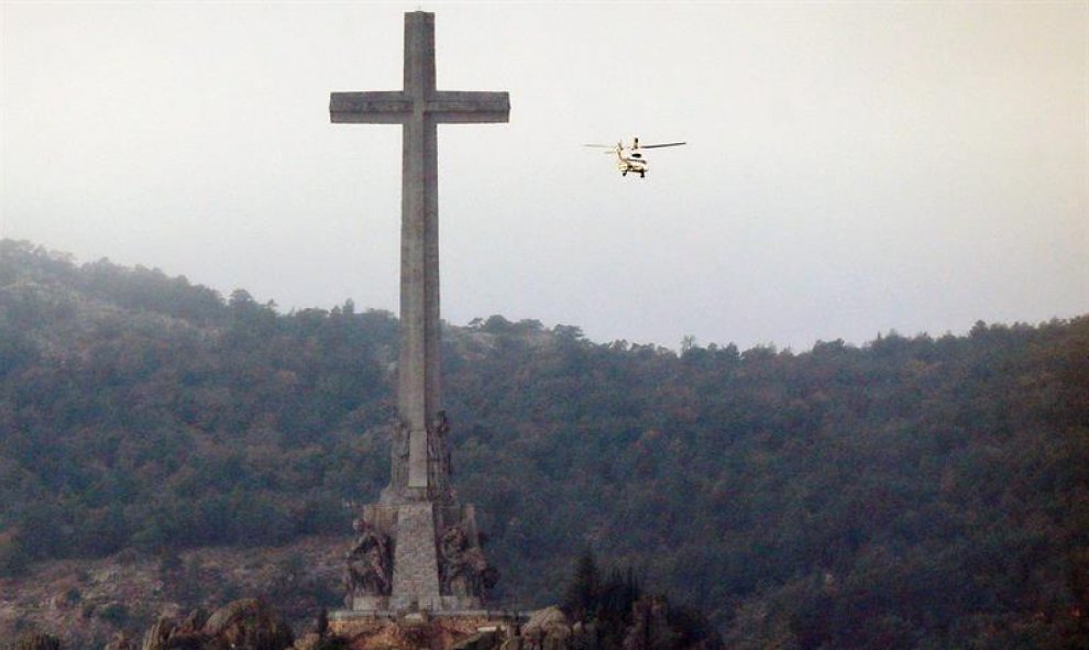 Vista del helicóptero junto a la cruz del Valle de los Caídos de donde serán exhumados los restos de Francisco Franco y trasladados al cementerio de El Pardo-Mingorrubio para su reinhumación. EFE/Chema Moya