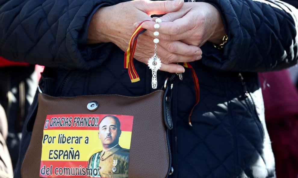 Una mujer franquista sostiene un rosario mientras reza afuera del cementerio Mingorrubio-El Pardo, en Madrid. REUTERS / Sergio Perez