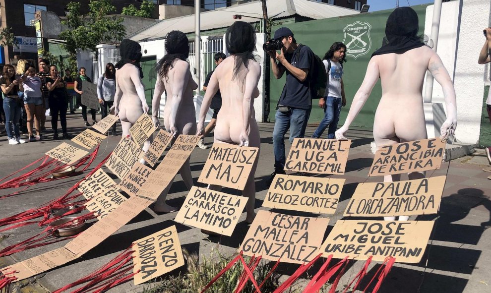 28/10/2019.- Manifestantes desnudos con carteles con los nombres de los 20 fallecidos en las protestas de Chile, este lunes frente a una comisaría de Carabineros, en Santiago (Chile). EFE/Fernando Gimeno