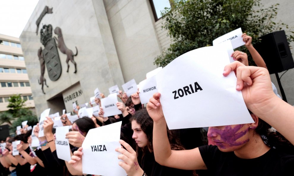 En Las Palmas de Gran Canaria jóvenes de dos centros de enseñanza de secundaria han mostrado hojas con los nombres de las asesinadas por la violencia de género durante el acto institucional del Gobierno de Canarias./ Ángel Medina G. (EFE)