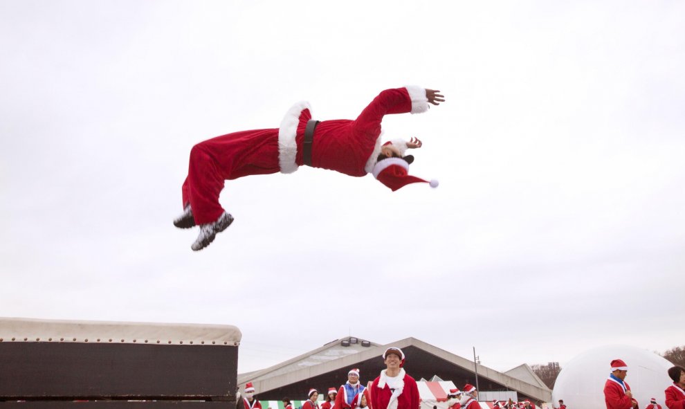 Un hombre vestido de Santa Claus salta durante una carrera solidaria en Tokio. EUROPA PRESS