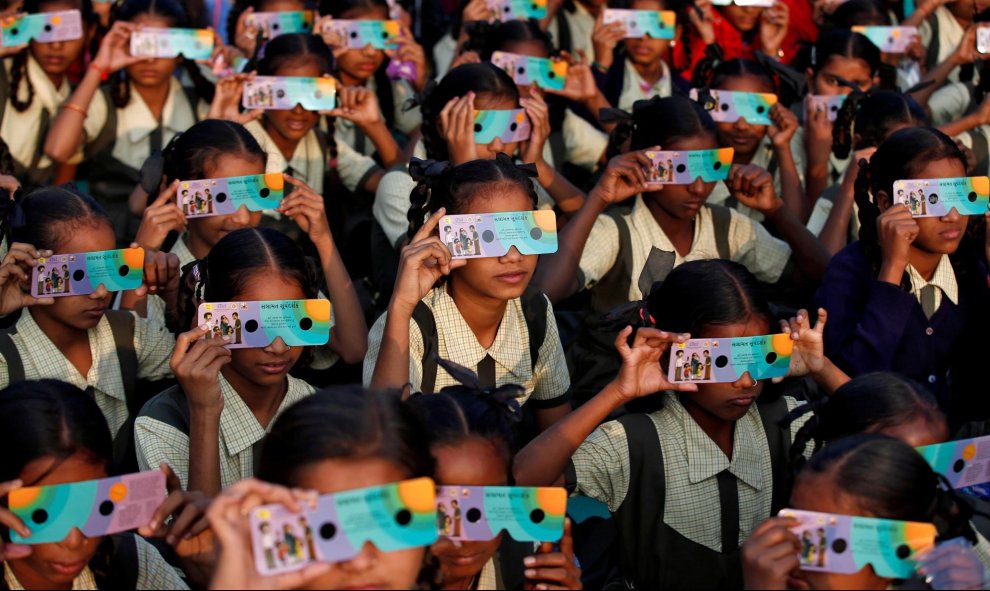 26/12/2019 - Niñas usando gafas solares para ver el eclipse en Ahmedabad, India. REUTERS / Amit Dave