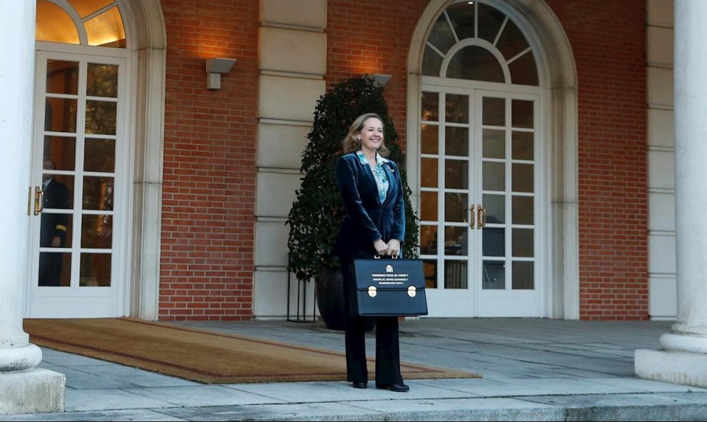 14/01/2020.- La vicepresidenta del Gobierno y ministra de Asuntos Económicos y Transformación Digital, Nadia Calviño, posa con su cartera a su llegada al Palacio de la Moncloa para asistir al primer Consejo de Ministros del Ejecutivo de coalición presidid