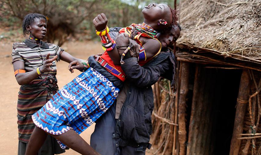 SIEGFRIED MODOLA (REUTERS) Un hombre sostiene a una niña que trata de escapar cuando es consciente de que va a ser casada contra su voluntad en Marigat (Kenia). Como manda la tradición de la tribu Polok, el futuro marido llegó a la casa de la familia co