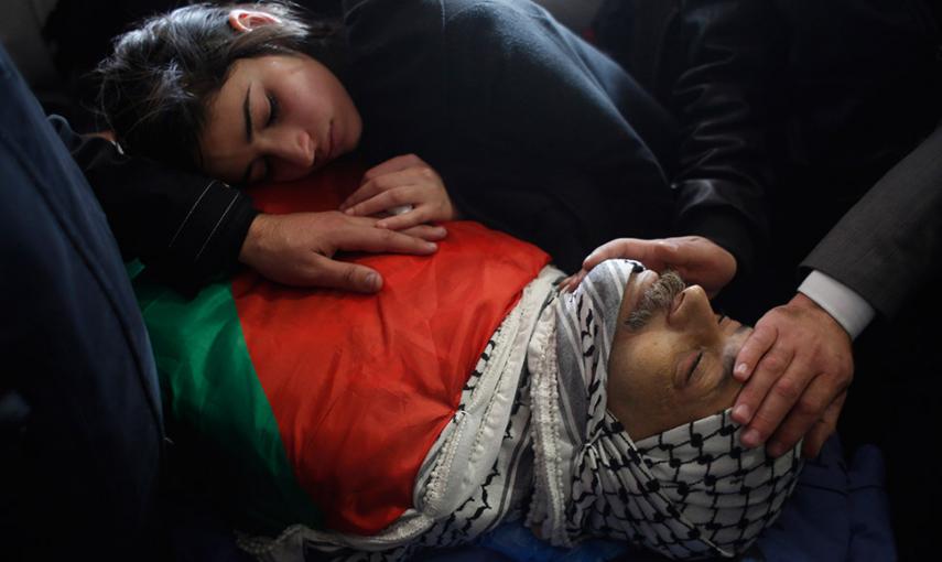 La hija del ministro palestino Ziad Abu Ein, llora sobre su cuerpo durante el funeral en la ciudad cisjordana de Ramala. Abu Ein murió a manos de un policía israelí, lo que ha elevado las tensiones en la zona. //  MOHAMAD TOROKMAN (REUTERS)