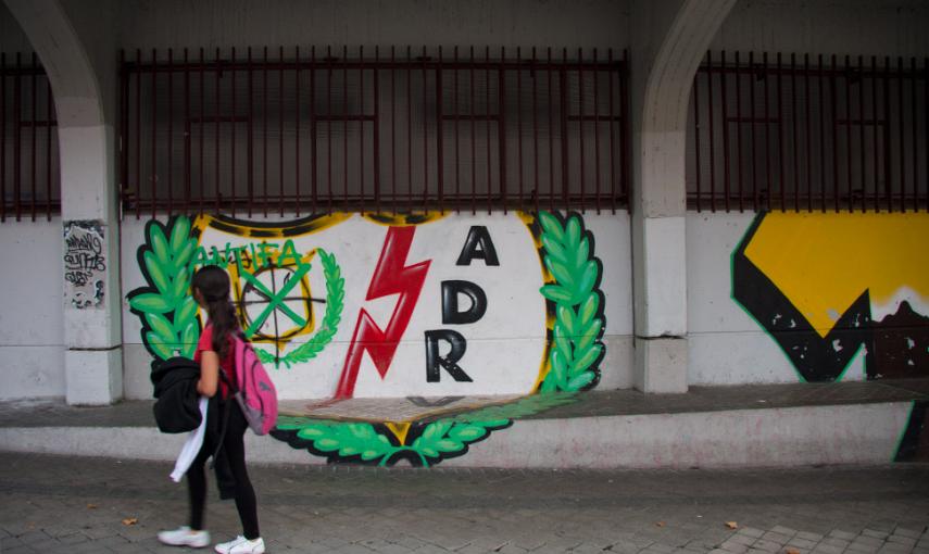 Una niña pasa junto al estadio al regresar del colegio. // CHRISTIAN GONZÁLEZ