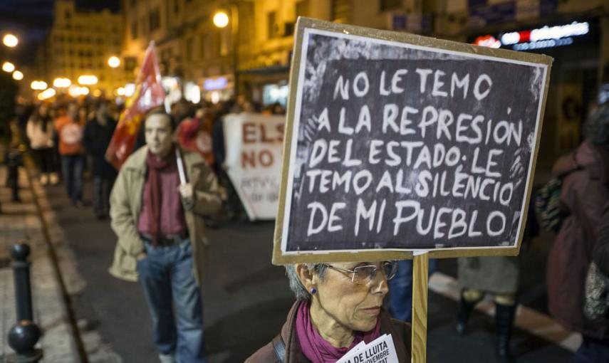 Una mujer porta una pizarra con un mensaje durante "Marxes per la dignitat", en Valencia. // EFE