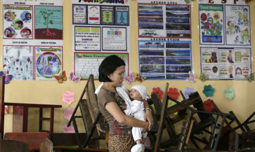 Una mujer con su bebé de dos meses en uno de los centros de evacuación de Manila. // EFE/EPA/DENNIS M. SABANGAN
