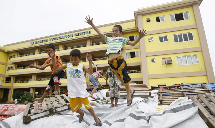 Un grupo de niños filipinos juegan junto a uno de los centros de evacuación en Manila. // EFE/EPA/DENNIS M. SABANGAN