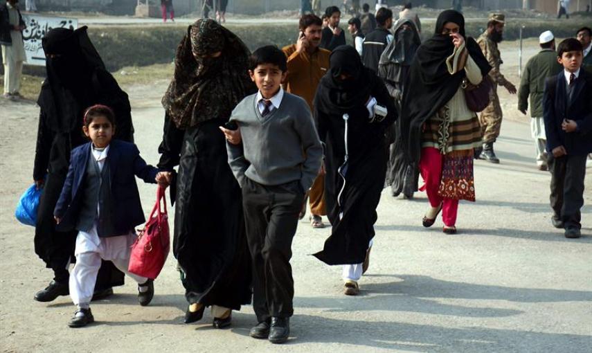 Varios alumnos acompañan a sus madres tras ser rescatados por las Fuerzas de Seguridad durante el ataque talibán contra un colegio gestionado por el Ejército en Peshawar (Pakistán). EFE/Bilawal Arbab