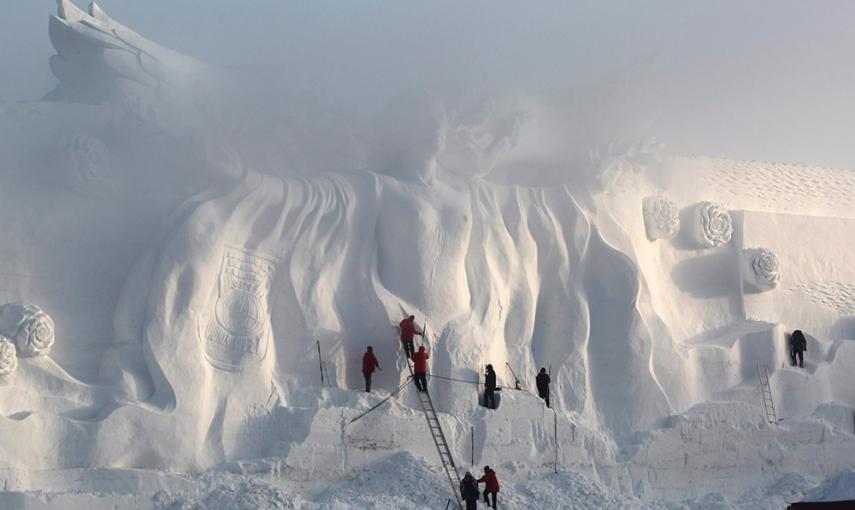 Varios artistas pulen una escultura de nieve en un parque en Changchun, provincia de Jilin. /REUTERS/STR