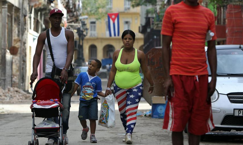 Una mujer vestida con la bandera de Estados Unidos camina junto a su familia en una calle de La Habana (Cuba). EFE/Alejandro Ernesto