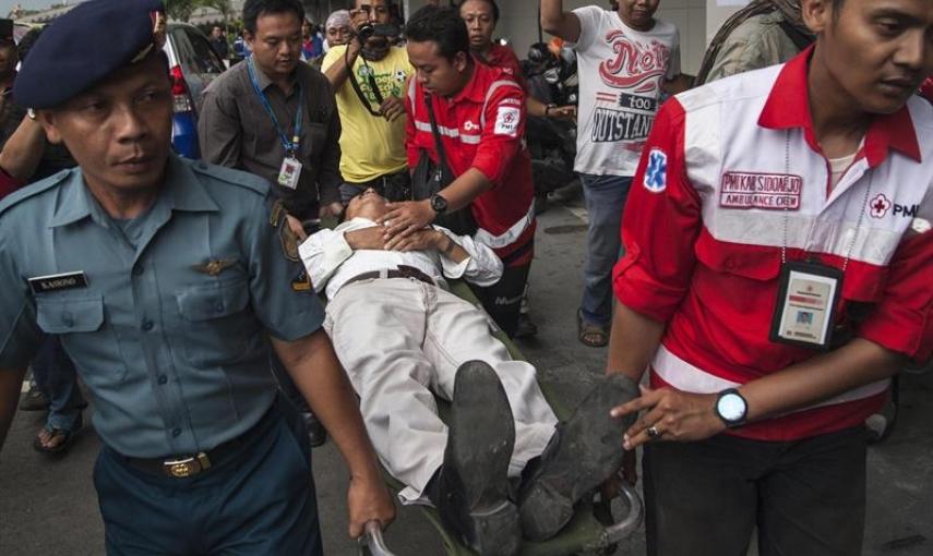 Personal de seguridad del aeropuerto de Juanda en Surabaya (Indonesia) ayudan a un hombre afectado al escuchar que los restos del avión desaparecido de AirAsia han sido localizados en alta mar. EFE