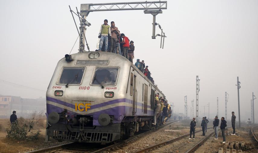 Passengers crowd atop a train as they travel on a cold winter morning at a railway station in Ghaziabad on the outskirts of New Delhi December 29, 2014. REUTERS/Anindito Mukherjee