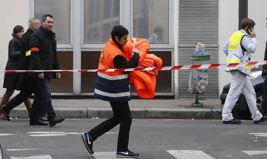 Un trabajador sanitario pasa cerca de las oficinas del semanario satírico francés 'Charlie Hebdo' tras el ataque contra la redacción que ha provocado  doce muertos, entre ellos dos policías. EFE/Ian Langsdon