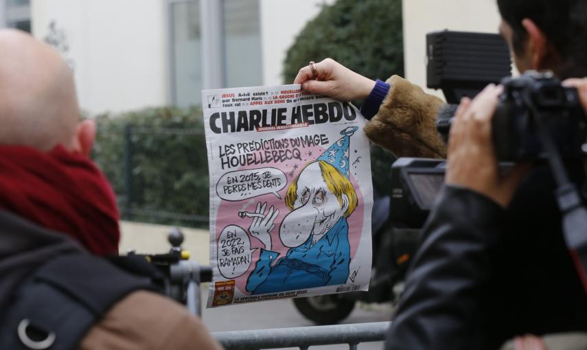 Un periodista sostiene un ejemplar de la revista 'Charlie Hebdo' con una caricatura del escritor francés Michel Houellebecq, junto al cordón policial cerca de las oficinas de la revista. REUTERS/Jacky Naegelen