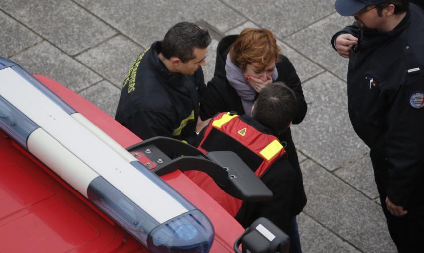 Una mujer es atendida por un bombero cerca de las oficinas de la revista 'Charlie Hebdo'. REUTERS/Christian Hartmann