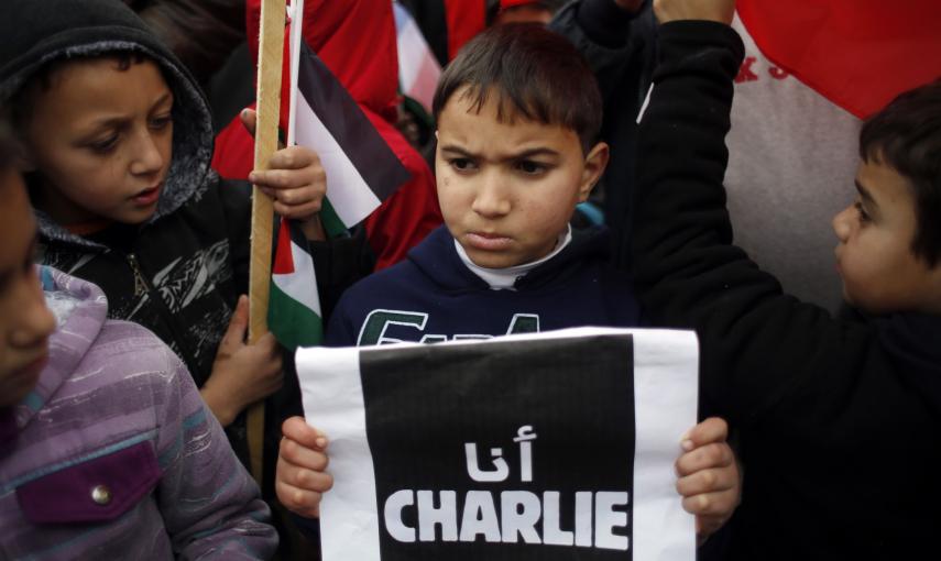 A Palestinian boy holds up a sign during a protest against the attack in Paris on satirical French newspaper Charlie Hebdo, in the West Bank city of Ramallah January 11, 2015. The sign reads, "I am Charlie". REUTERS/Mohamad Torokman