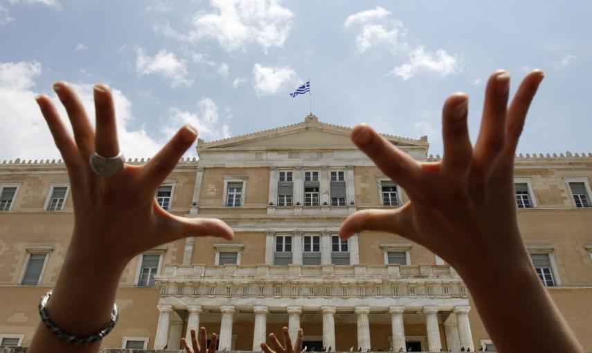 Un manifestante levanta las manos frente al Parlamento griego durante una manifestación contra las medidas de austeridad del Gobierno en Atenas (29 de junio 2010). REUTERS / John Kolesidis