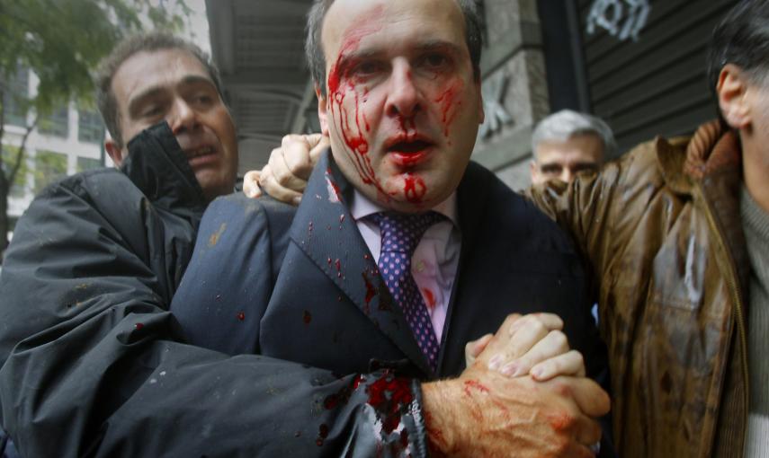 El ex ministro conservador Kostis Hatzidakis cubierto de sangre después de un incidente con un grupo de manifestantes que lo atacaron con piedras y palos, gritando "¡Ladrones! ¡La culpa es vuestra!" (15 de diciembre 2010). REUTERS / Yannis Behrakis