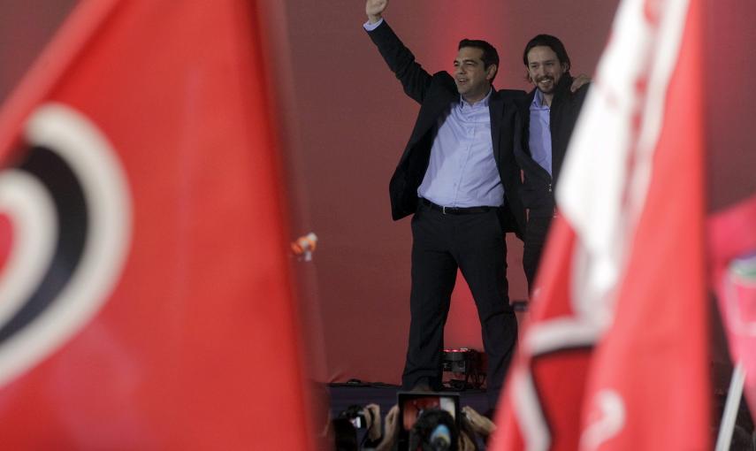 El líder del partido español Podemos, Pablo Iglesias, saluda acompañado por el líder de Syriza, Alexis Tsipras. EFE/Yannis Kolesidis