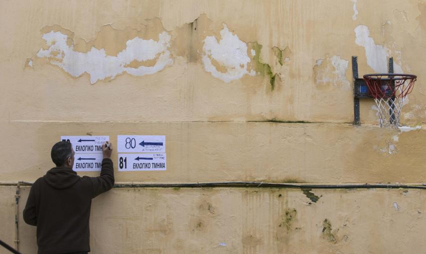 Un funcionario de la comisión electoral escribe en un cartel en un colegio elecoral en Atenas. REUTERS/Marko Djurica