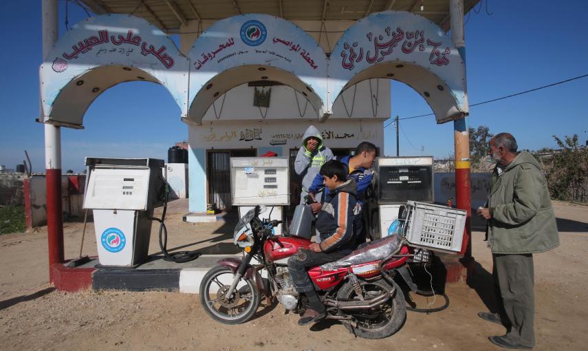 Un joven palestino llena un bidón en un motocicleta en una gasolinera  en la franja de Gaza. REUTERS/Ibraheem Abu Mustafa