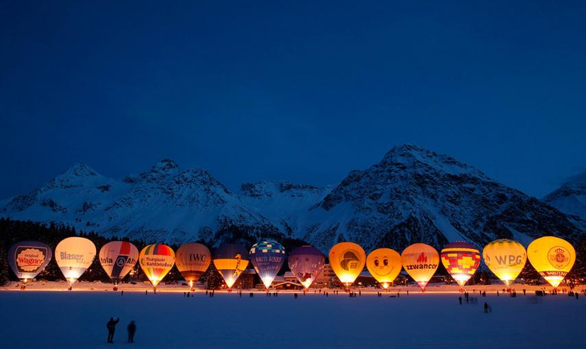 Los espectadores toman fotos de los globos aerostáticos, durante la Semana Internacional del Globo en la localidad suiza de Arosa. /CHRISTIAN HARTMANN (REUTERS)