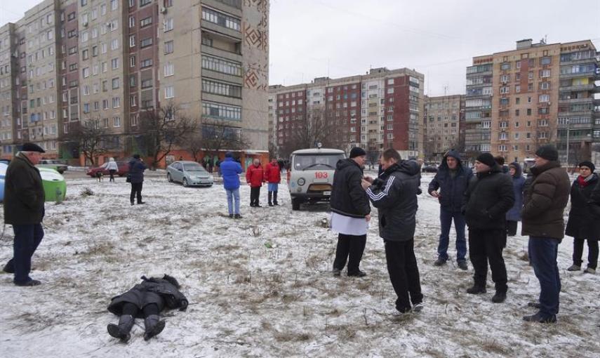 Varias personas observan el cuerpo sin vida de una mujer tras un bombardeo en una calle de Kramatorsk, Ucrania, el 10 de febrero del 2015. El presidente de Ucrania, Petró Poroshenko, denunció hoy que las milicias prorrusas atacaron con misiles Tornado la