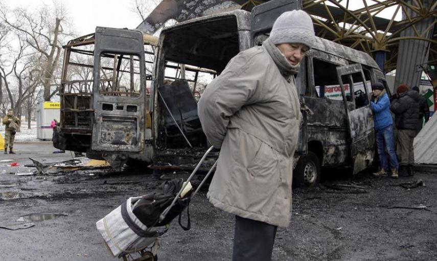 Una mujer pasa por la zona donde impactaron varios proyectiles de artillería en Donetsk (Ucrania), hoy, miércoles 11 de febrero de 2015. Al menos seis civiles murieron y otros ocho resultaron heridos por fuego de artillería en una estación de transporte p