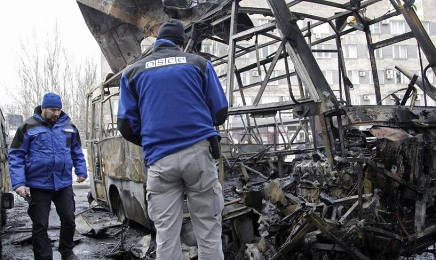 Dos observadores de la OSCE investigan la zona donde impactaron varios proyectiles de artillería en Donetsk (Ucrania), hoy, miércoles 11 de febrero de 2015. Al menos seis civiles murieron y otros ocho resultaron heridos por fuego de artillería en una esta