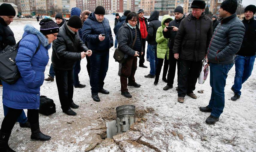 Un grupo de personas mira y toma fotos de los restos de un cohete, en una calle de la ciudad de Kramatorsk, en el este de Ucrania. /GLEB GARANICH (REUTERS)