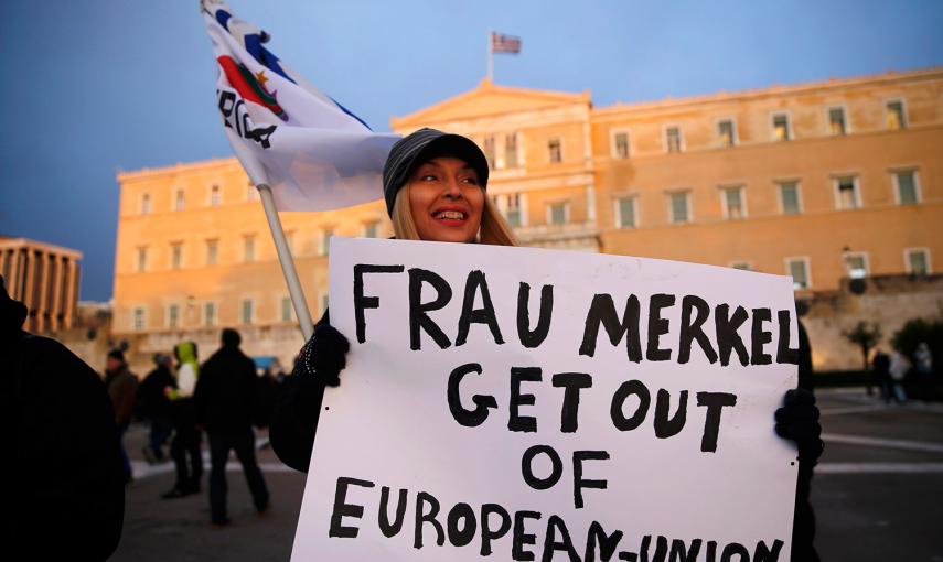Una mujer muestra un lema contra la canciller alemana Angela Merkel, durante una manifestación contra la austeridad frente al Parlamento griego, en Atenas. /YANNIS BEHRAKIS (REUTERS)