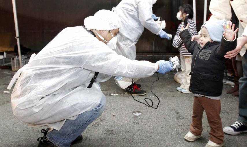 Miembros de los equipos de protección examinan a varios niños para detectar signos de la radiación en zona de la planta nuclear de Fukushima (13 de marzo de2011). REUTERS / Kim Kyung-Hoon