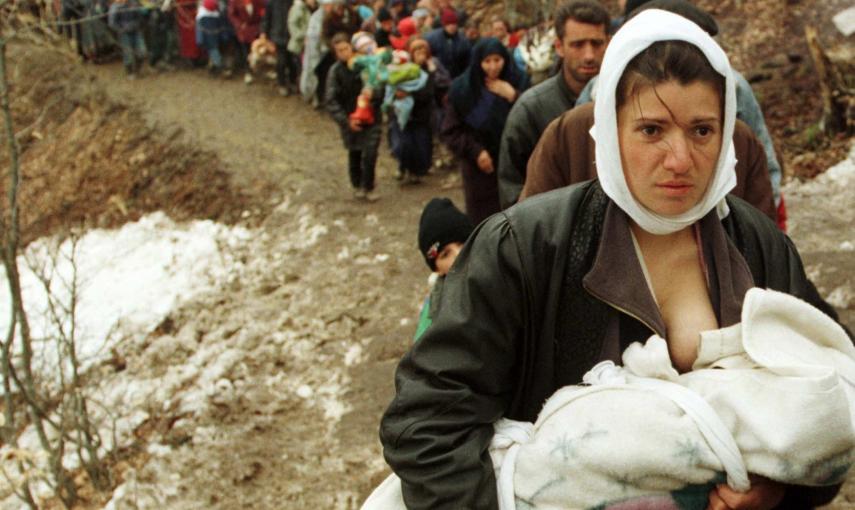 Una mujer de etnia albanesa alimenta a su bebé mientras a ella y acotros 2.000 refugiados, los desplazados por la guerra de Kosovo, se les permite entrar Macedonia (30 de marzo de 1999). REUTERS / Damir Sagolj