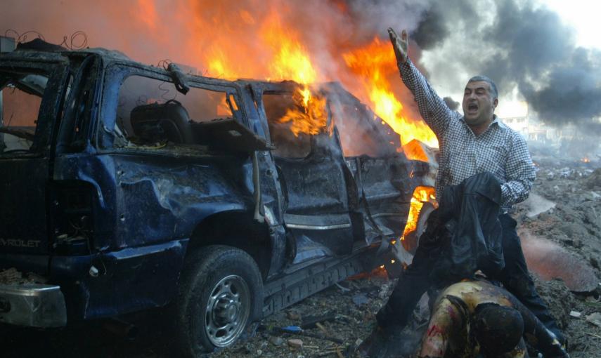 Un hombre grita pidiendo ayuda para un herido cerca del sitio donde explotó el  coche-bomba que mató en Beirut al ex primer ministro Rafik al-Hariri y a otras ocho personas (14 de febrero de 2005). REUTERS / Mohamed Azakir