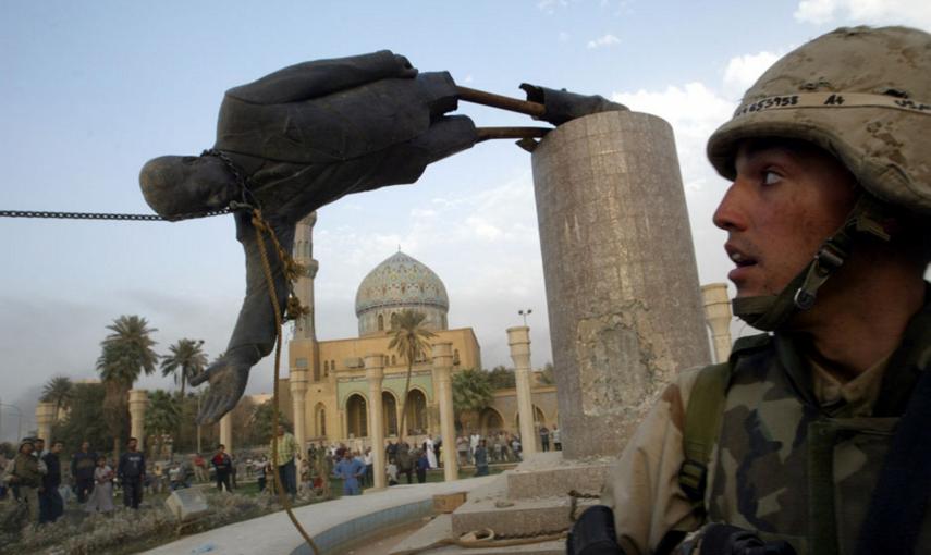 El marine Kirk Dalrymple junto a la estatua caida del presidente iraquí Saddam Hussein en el centro de Bagdad  (9 de abril de 2003). REUTERS / Goran Tomasevic