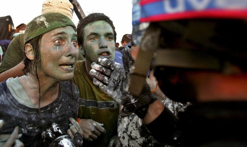 Colonos israelíes que se oponen a su  retirada de Gaza hablan con los policías encargados de vigilar la evacuación (18 de agosto de 2005). REUTERS / Nir Elias