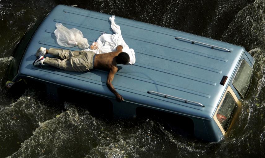 Un hombre se aferra a la parte superior de un vehículo antes de ser rescatado por la Guardia Costera de Estados Unidos de las calles inundadas de Nueva Orleans, en las secuelas del huracán Katrina (4 de septiembre de 2005). REUTERS / Robert Galbraith