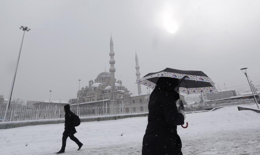 Ciudadanos de Estambul pasan frente a la Mezquita Nueva en el centro de la ciudad en medio del temporal de nieve./REUTERS-Murad Sezer