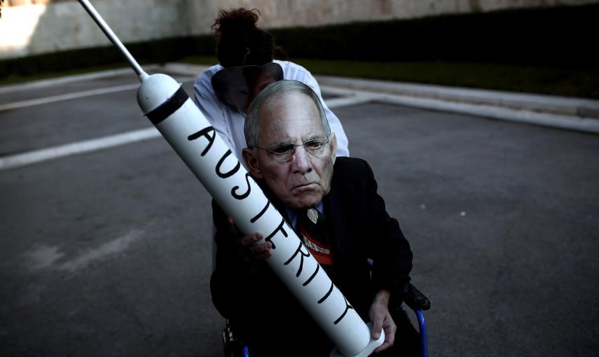 Un manifestante con una máscara del ministro alemán de finanzas, Wolfgang Schaeuble, durante una protesta anti-austeridad frente al Parlamento griego en Atenas. /ANGELOS TZORTZINIS (AFP)