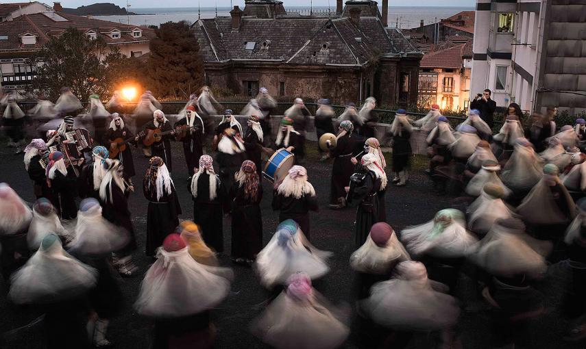 Varias mujeres vestidas de lamias, cantan y bailan durante el carnaval de Mundaka. /VICENTE WEST (REUTERS)